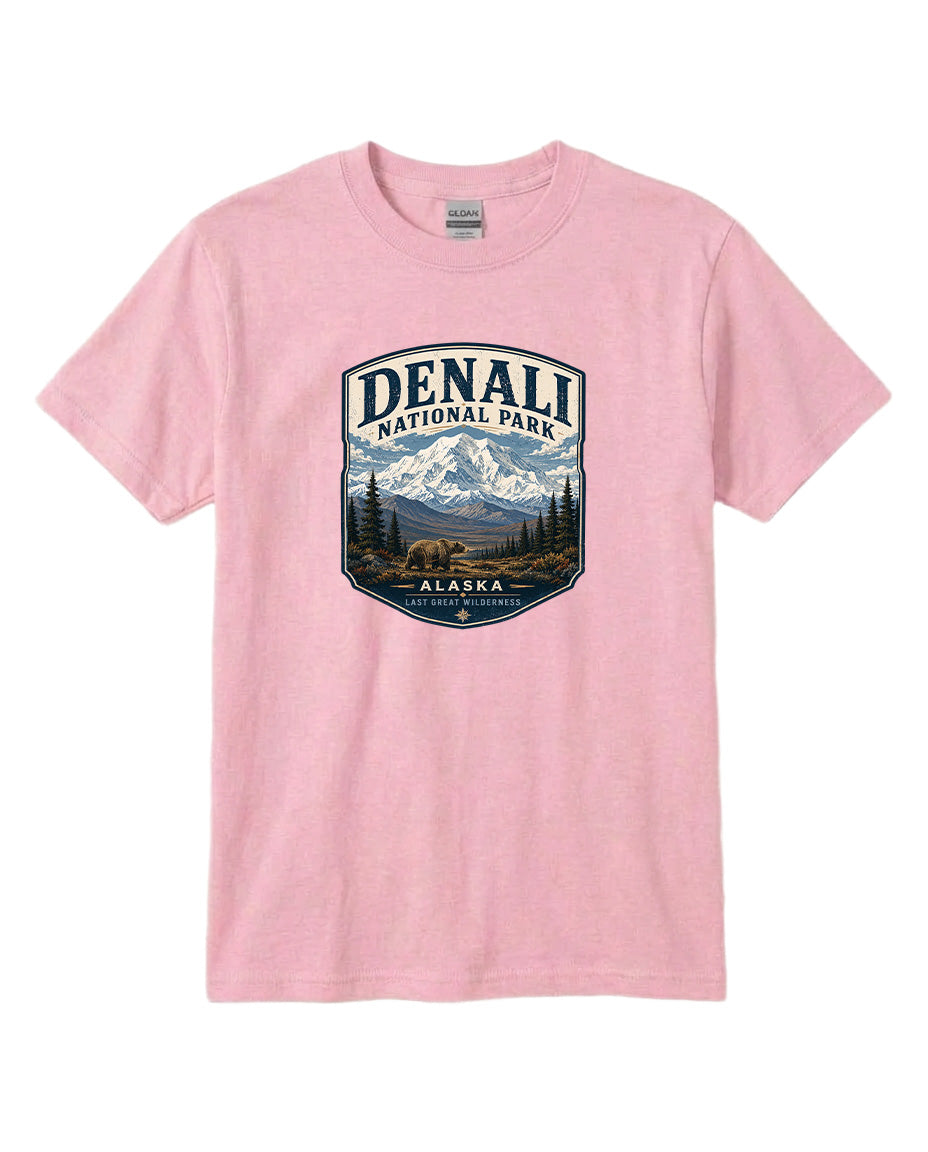 A pink t-shirt with a graphic design depicting a mountain landscape with a bear, surrounded by text that says "DENALI NATIONAL PARK ALASKA LAST GREATNESS".