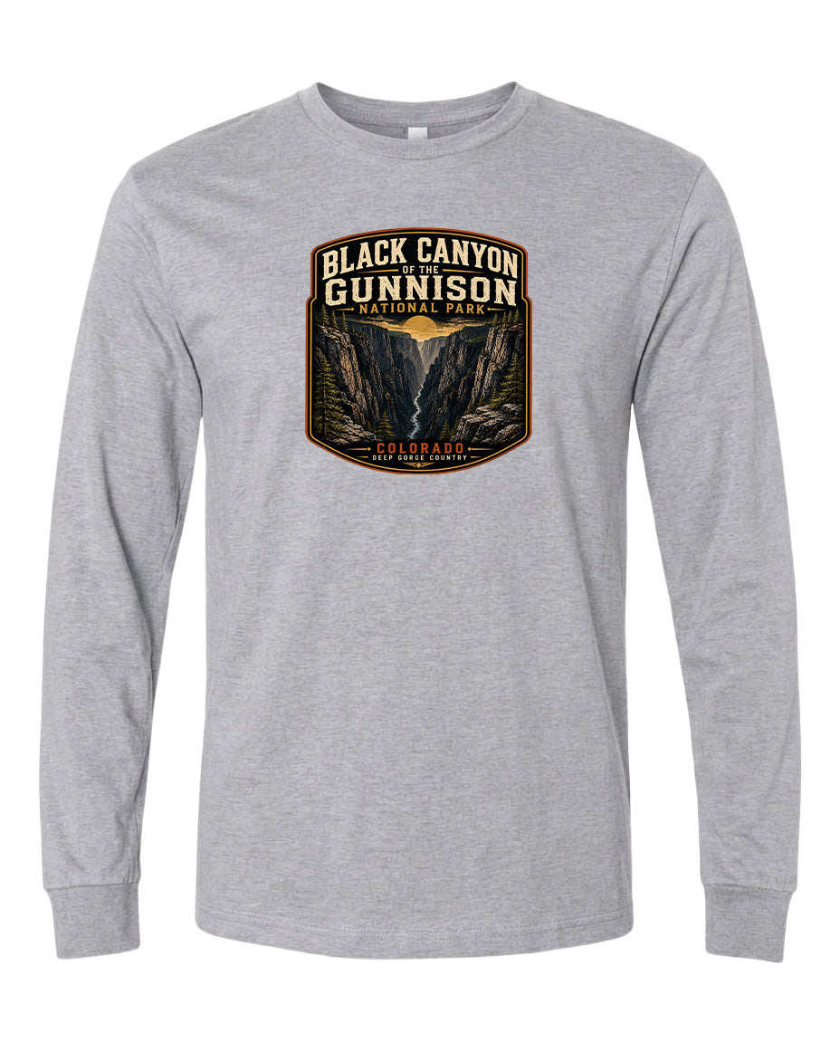 A gray long-sleeved t-shirt with a graphic design depicting a scenic mountain landscape, including a valley and a river.