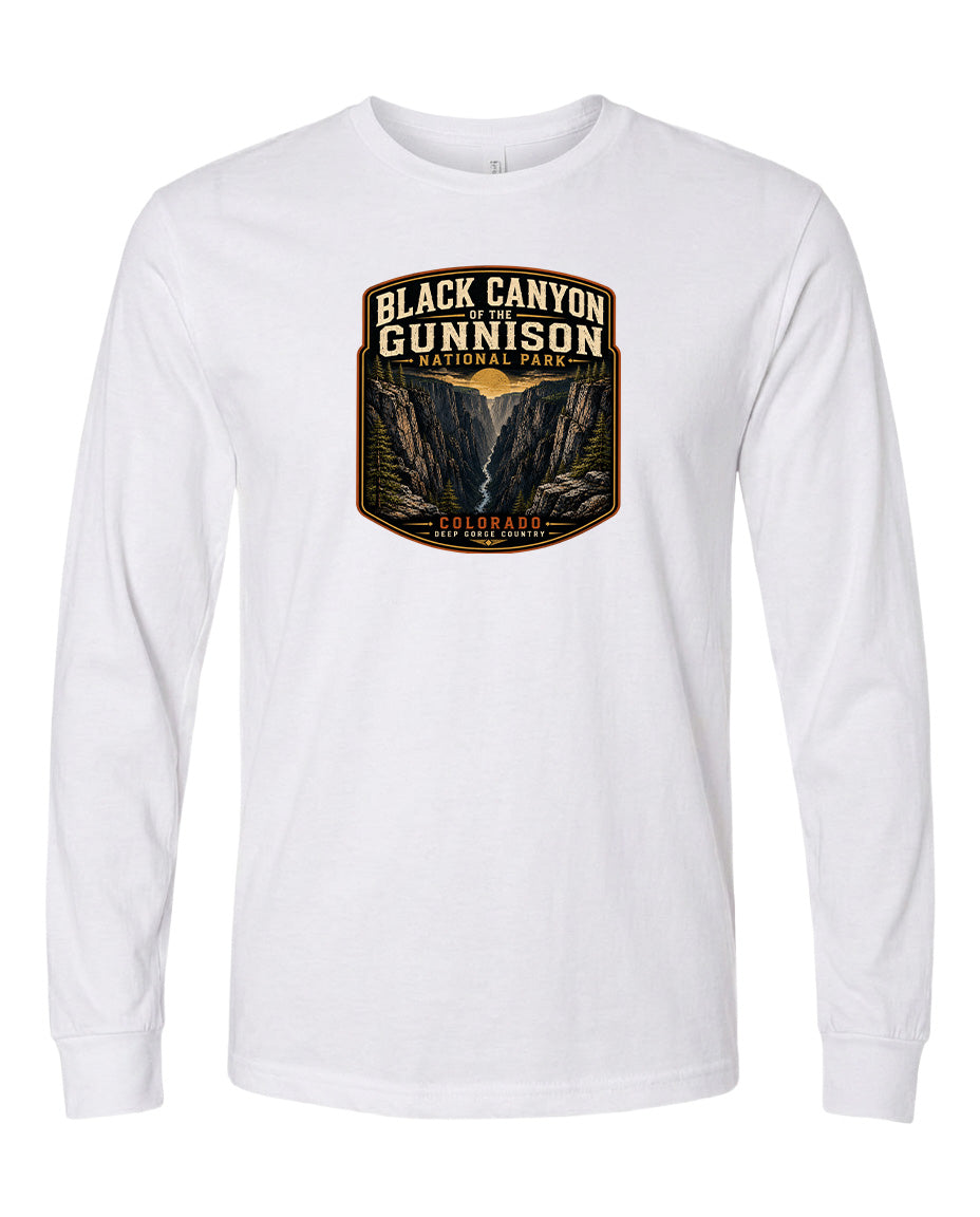 A white long-sleeved t-shirt with a graphic design depicting the Black Canyon of the Gunnison National Park in Colorado.