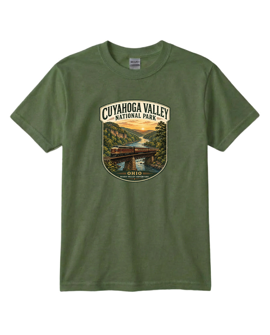 A green t-shirt with a graphic design depicting a scenic view of the Cuyaohoga Valley National Park, featuring a bridge, river, and sunset.