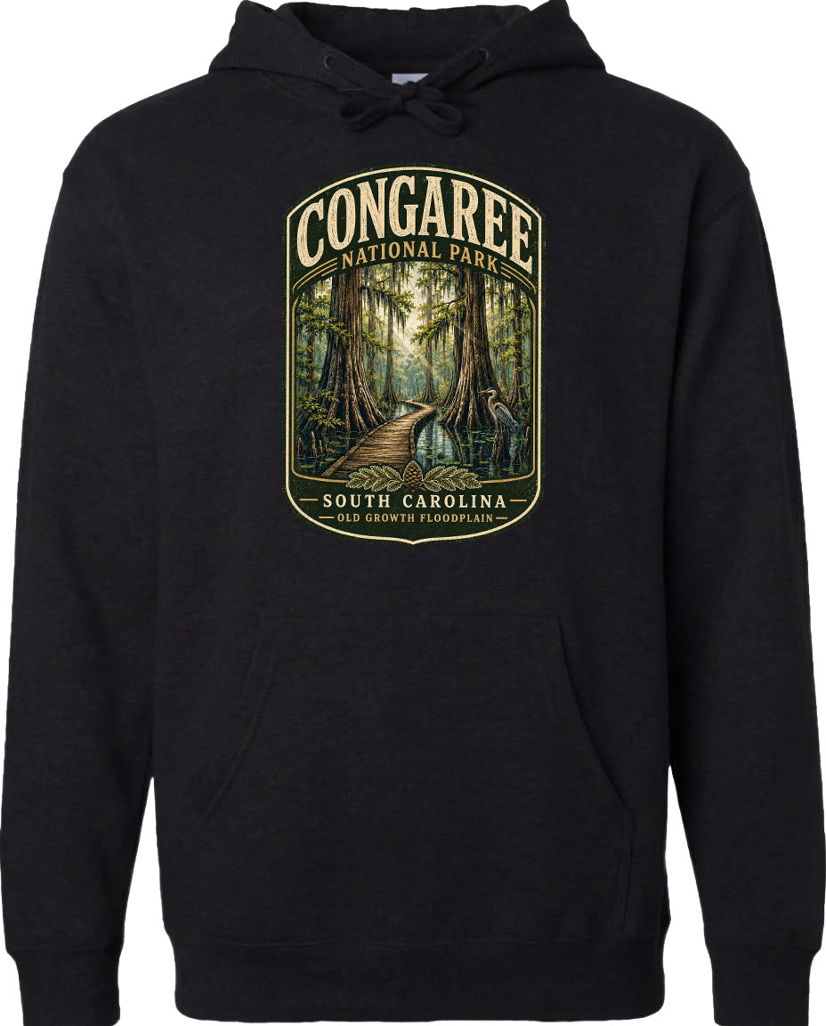A black hoodie with a graphic design depicting a forest scene with a path leading through it, surrounded by trees and foliage.