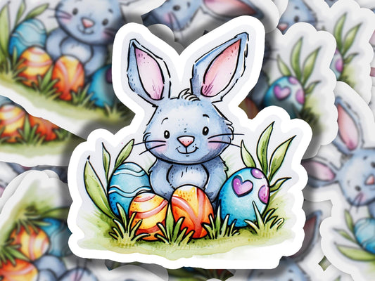 a sticker of a bunny with an egg in the grass
