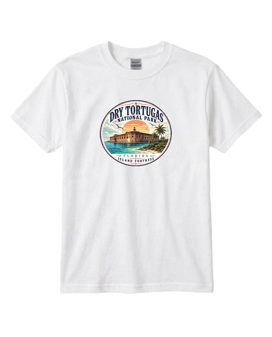 A white t-shirt with a circular graphic design featuring a tropical beach scene with palm trees, a building, and a sunset.
