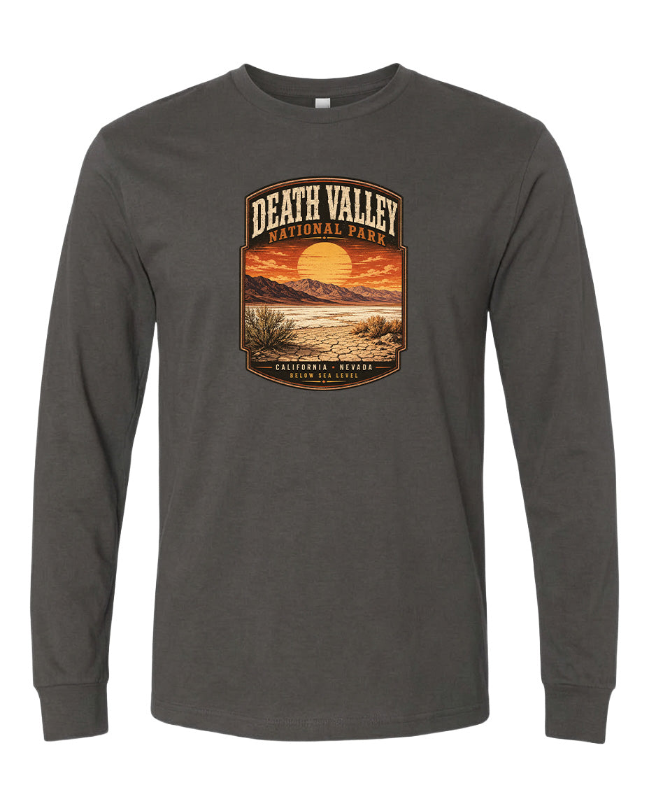 A long-sleeved gray t-shirt with a graphic design depicting a desert landscape with a sunset and mountains in the background.