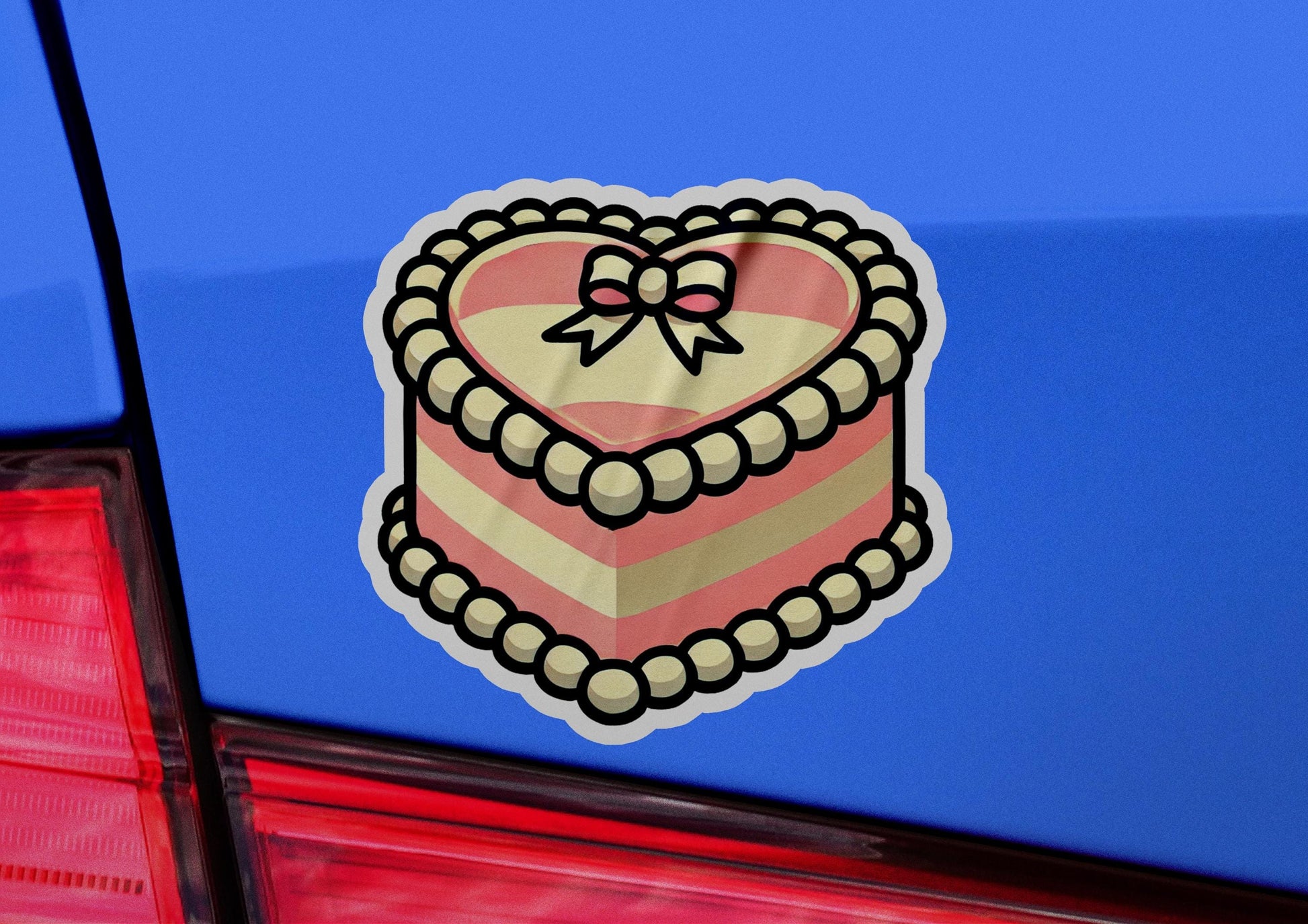a heart shaped cake sticker on the back of a car