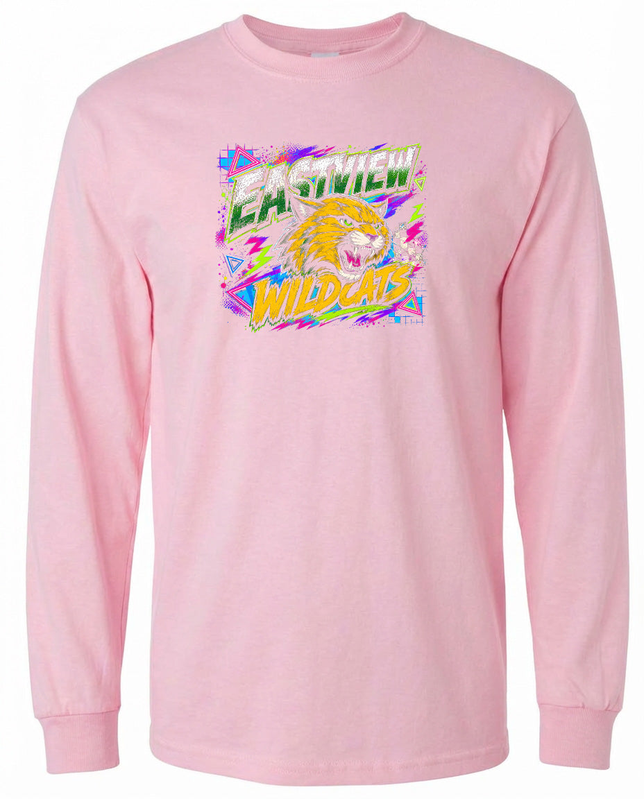 A pink long-sleeved t-shirt with a graphic design featuring a yellow and orange tiger or lion-like creature with a fierce expression, surrounded by colorful, abstract shapes and text.