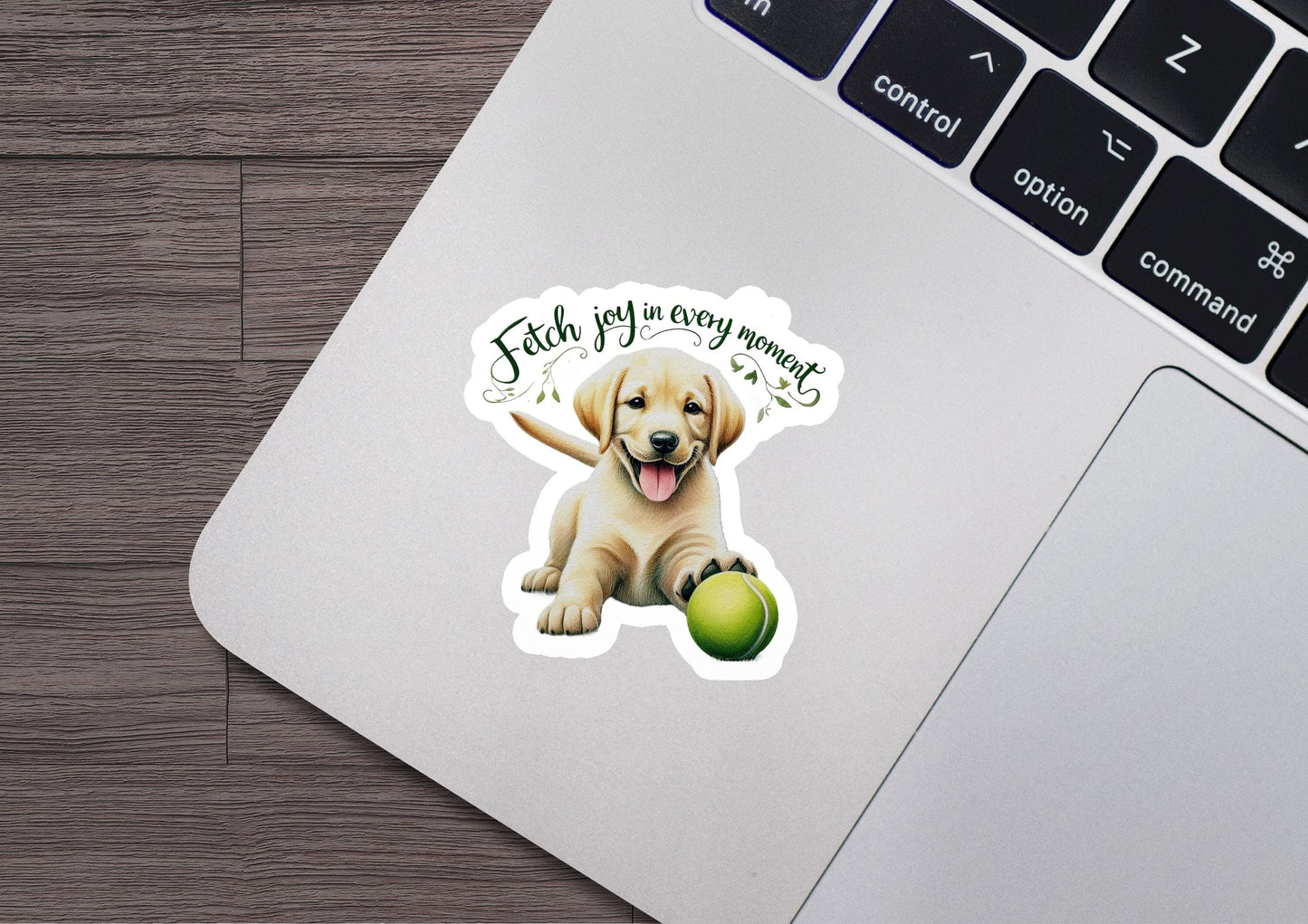 a laptop with a sticker of a dog holding a tennis ball