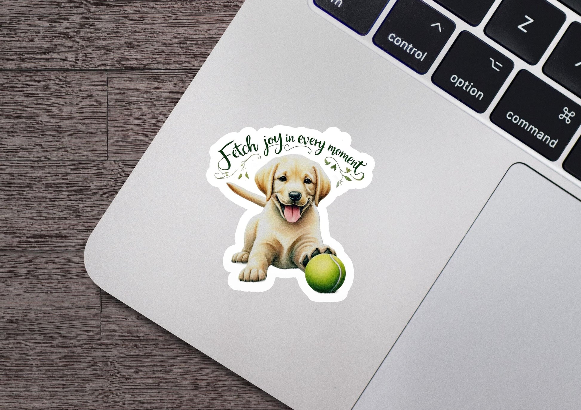 a laptop with a sticker of a dog holding a tennis ball
