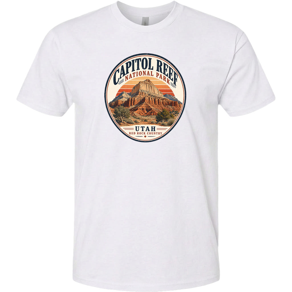 A white t-shirt with a circular design featuring the Capitol Reef National Park in Utah, surrounded by a sunset and desert landscape.