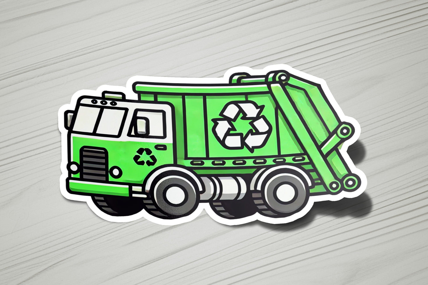 a green garbage truck sticker sitting on top of a wooden table