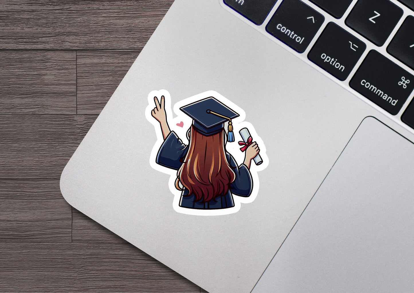 a laptop with a sticker of a girl in a graduation cap