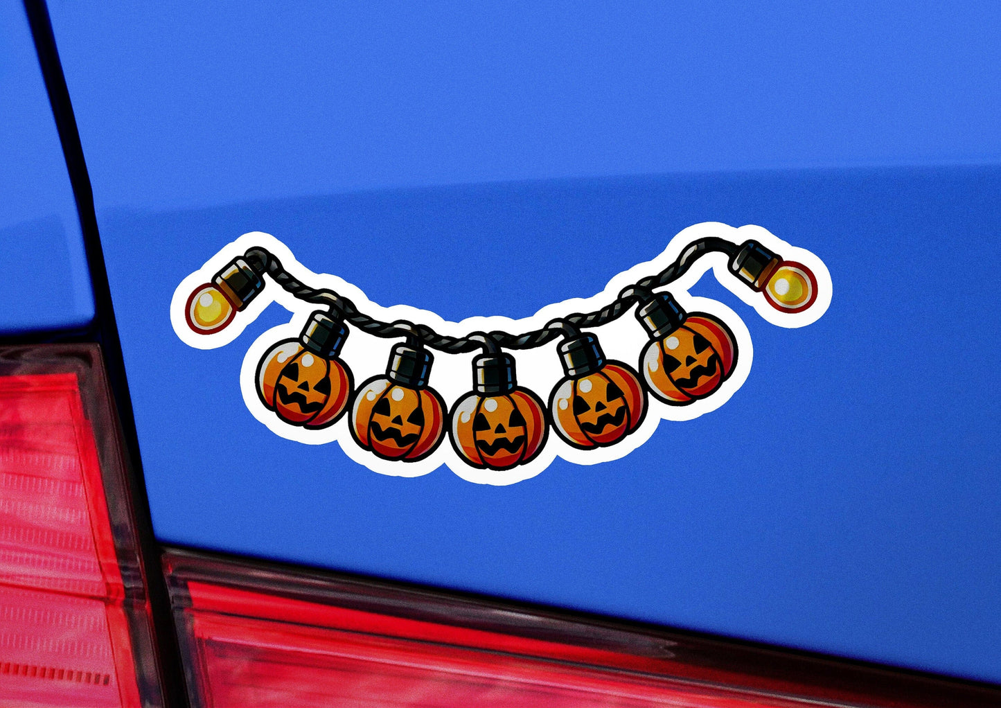 a blue car with a string of halloween lights on it