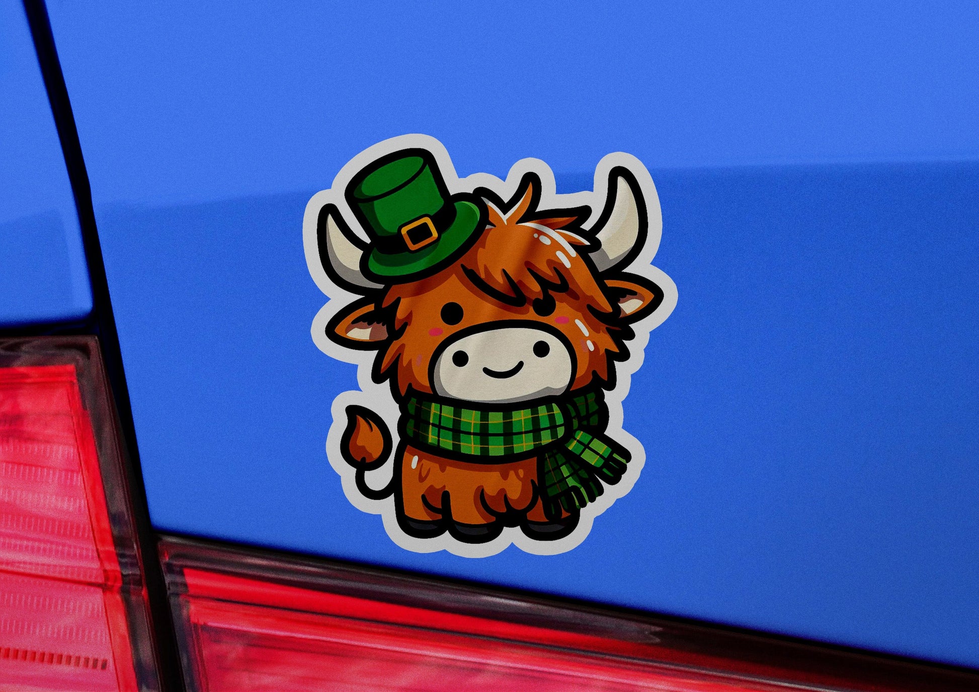 a sticker of a cow wearing a green hat and scarf