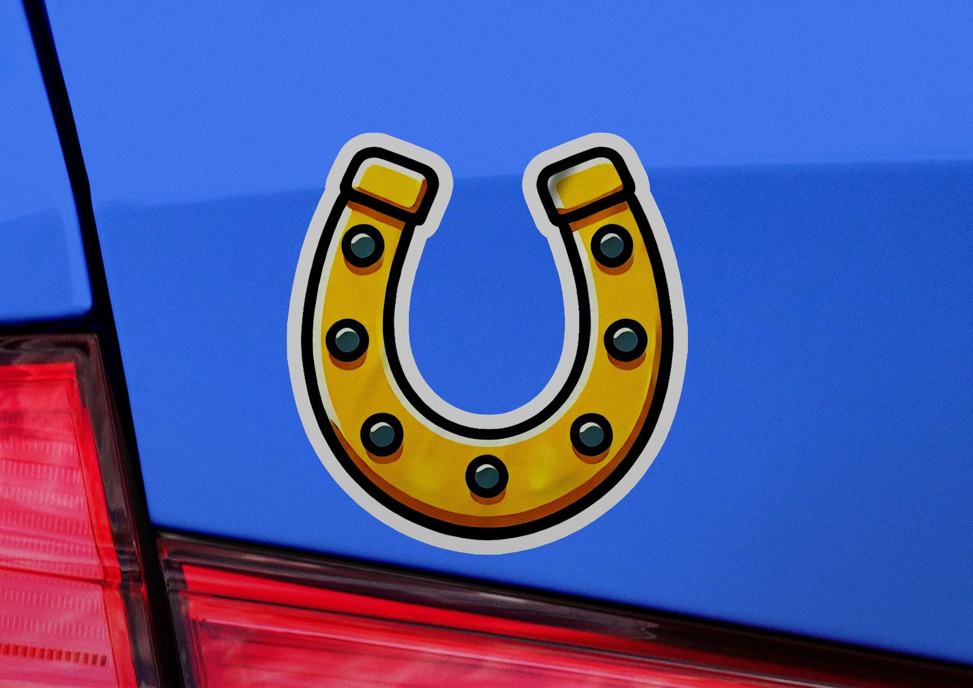 a yellow horseshoe sticker on the back of a blue car