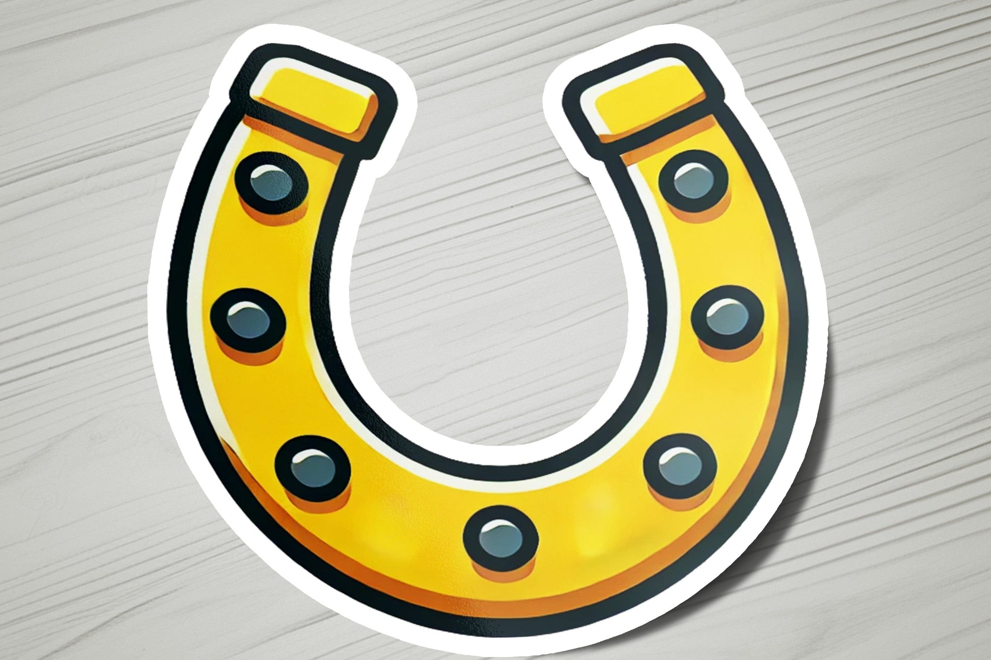 a sticker of a yellow horseshoe on a wooden surface
