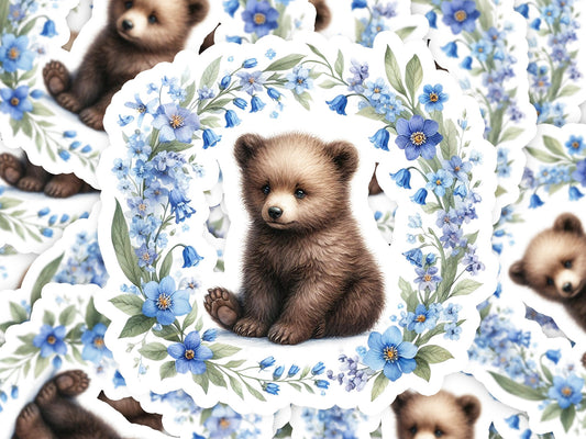 a picture of a brown bear surrounded by blue flowers