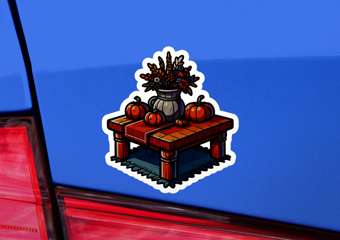 a sticker of a table with flowers and pumpkins on it