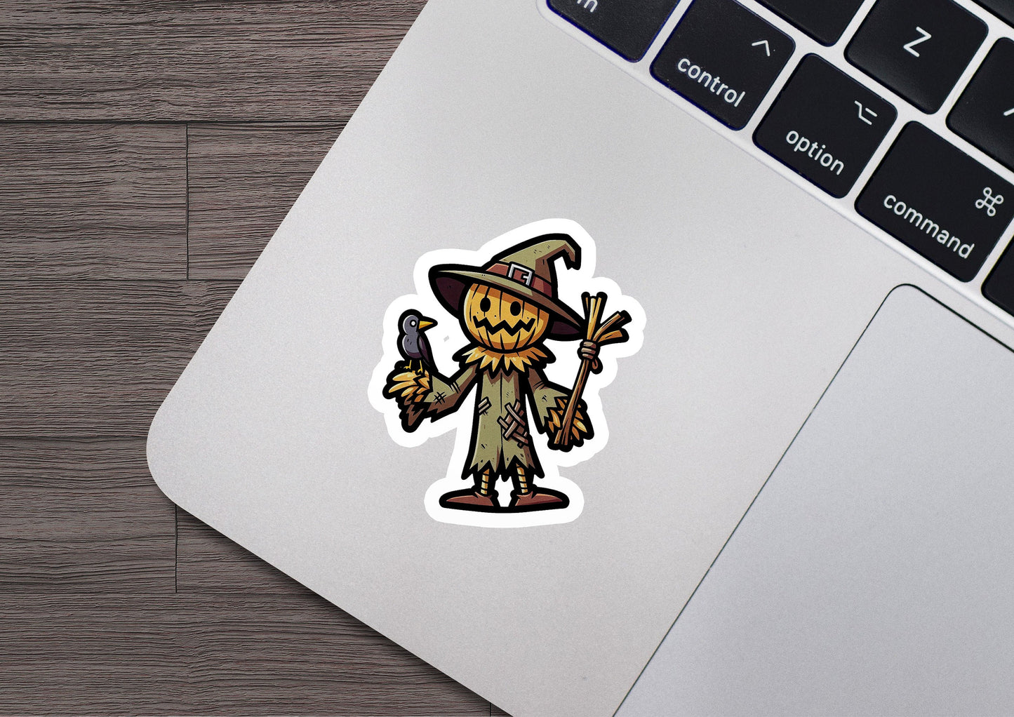 a laptop with a sticker of a scarecrow on it