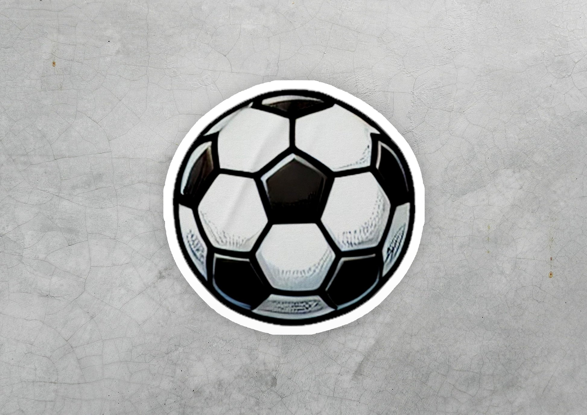 a sticker of a soccer ball on a concrete surface