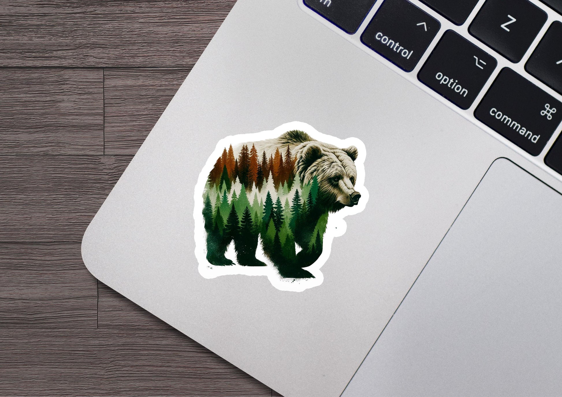 a bear sticker sitting on top of a laptop computer