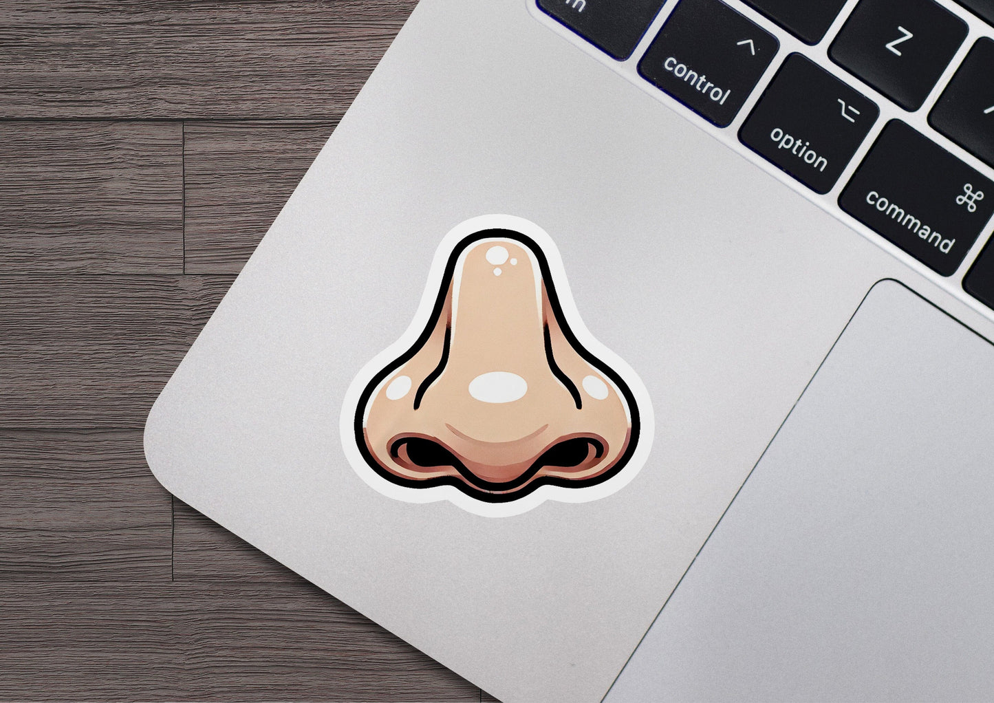a laptop with a sticker of a nose on it