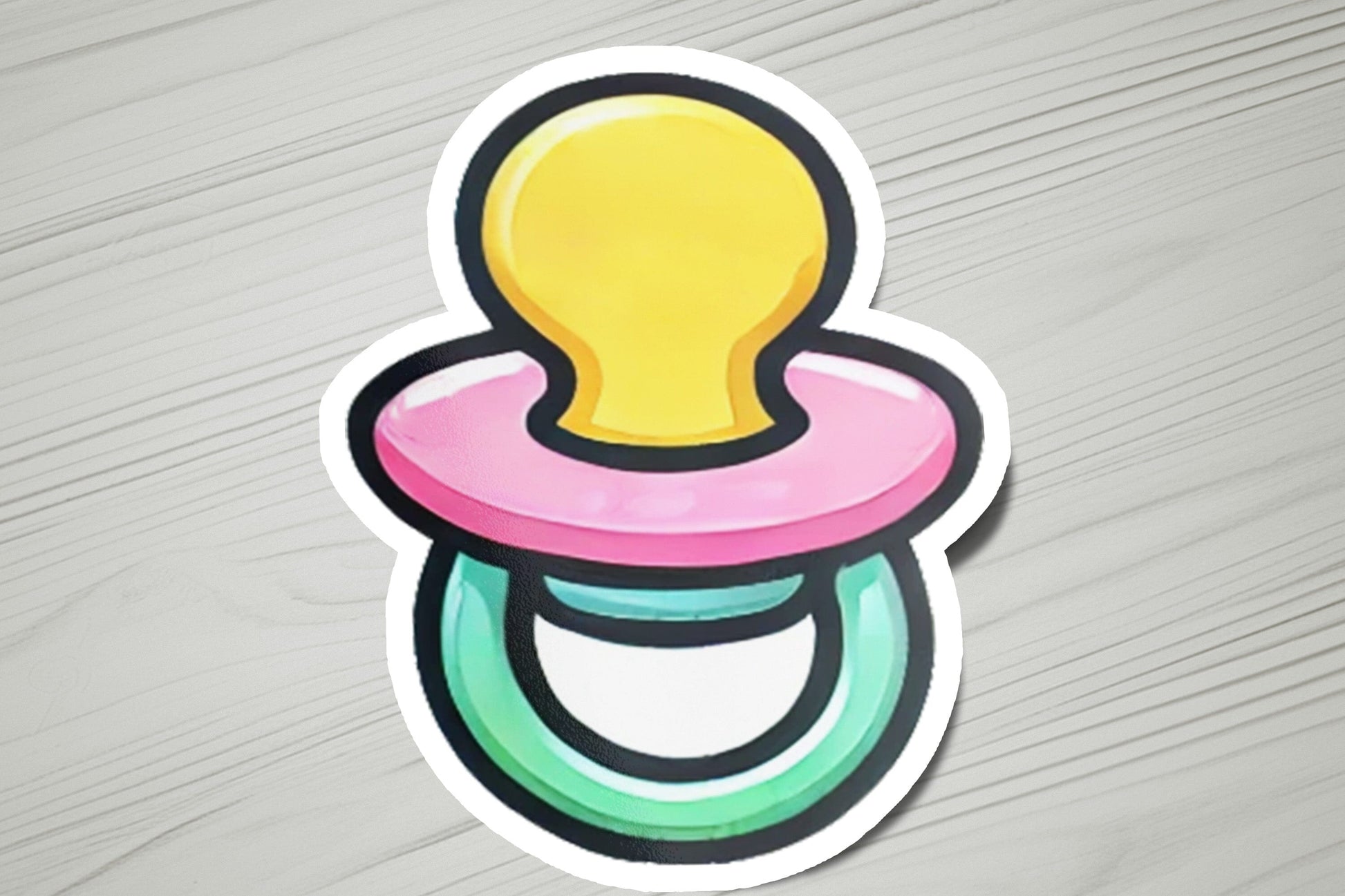 a sticker of a pacifier on a wooden surface