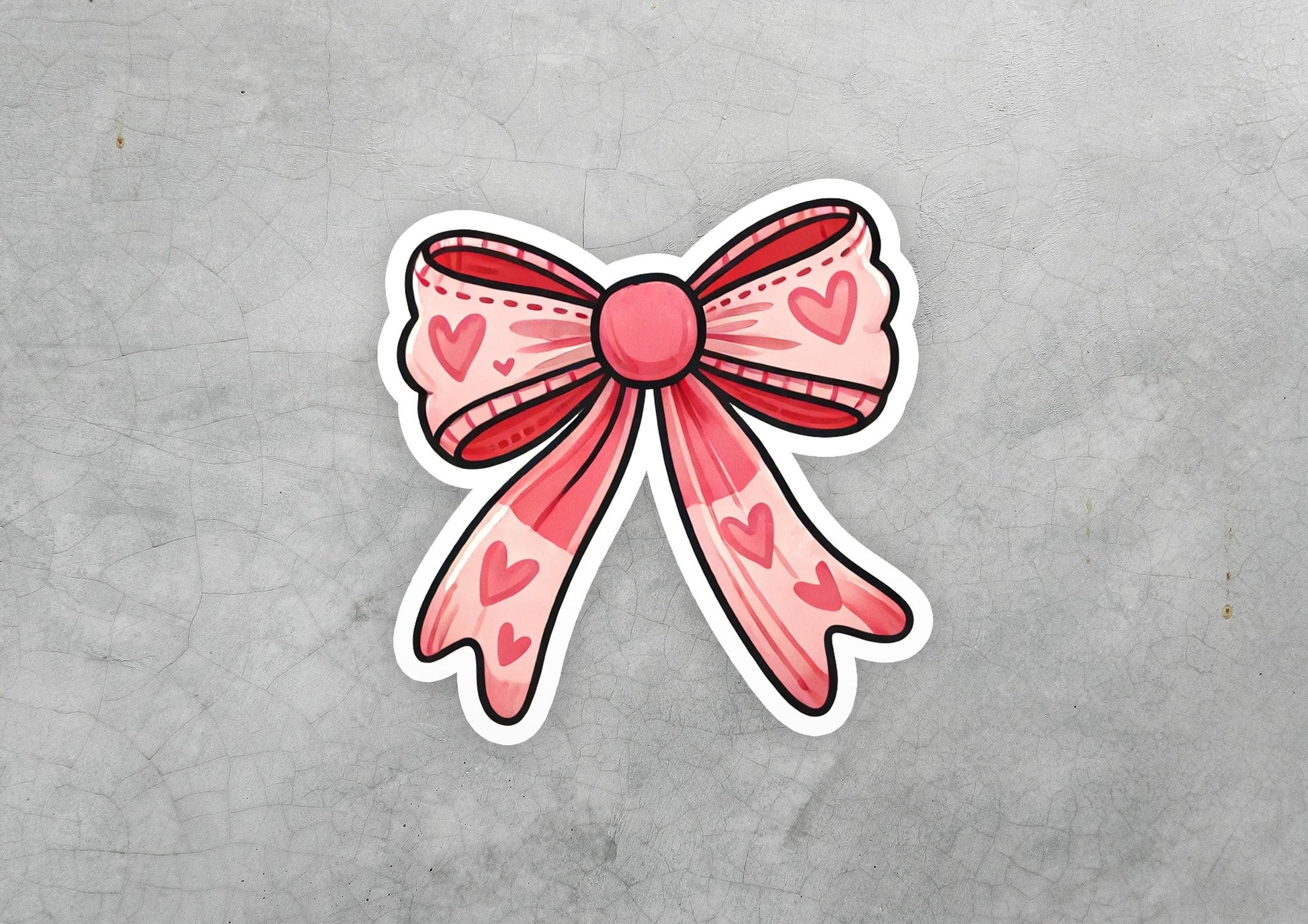 a sticker of a pink bow with hearts on it