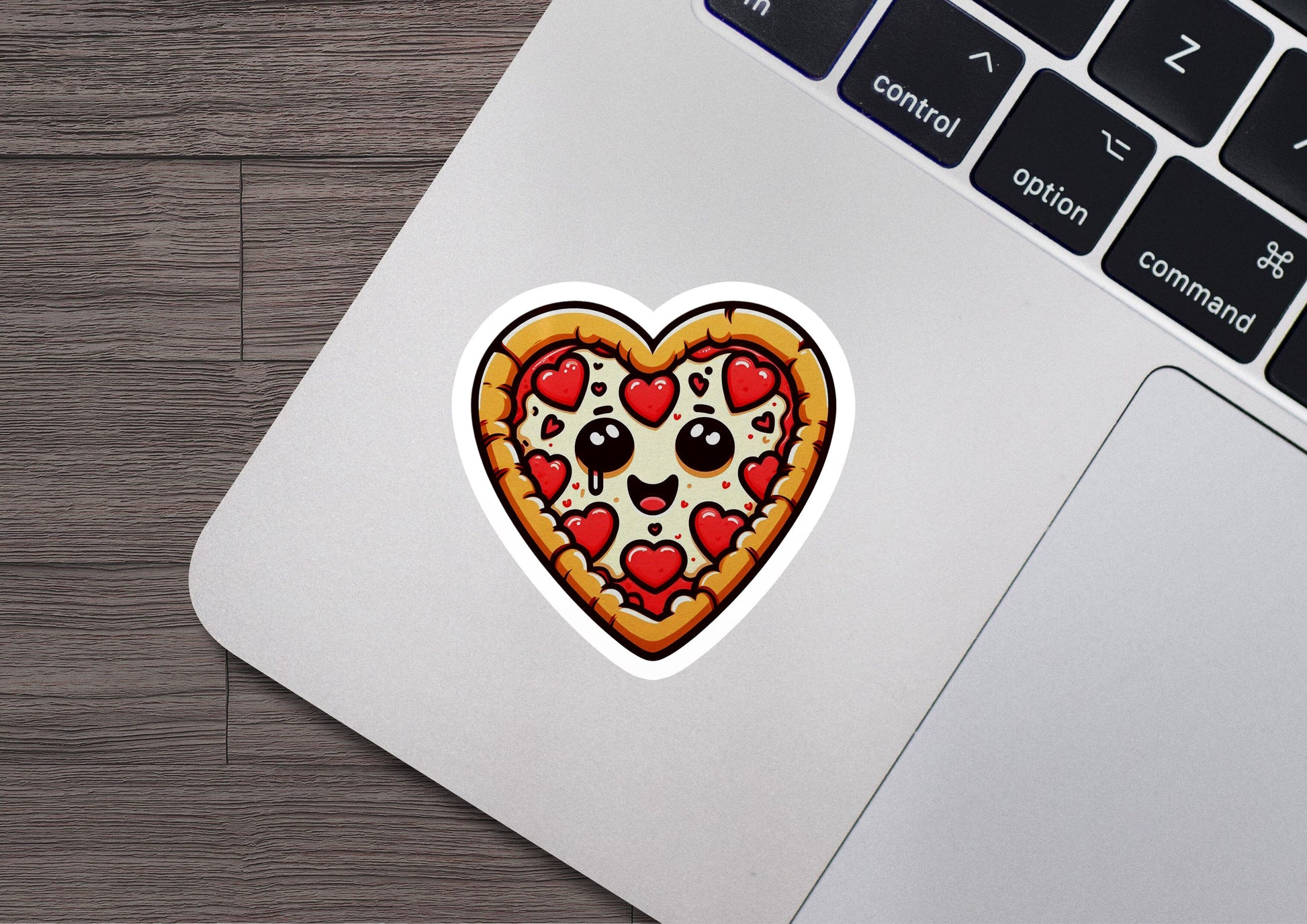 a heart shaped pizza sticker sitting on top of a laptop