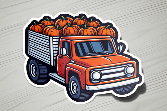 an orange truck filled with pumpkins on top of a wooden table