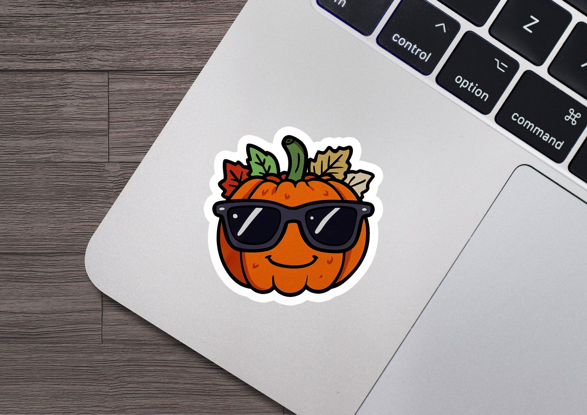 a laptop with a sticker of a pumpkin wearing sunglasses