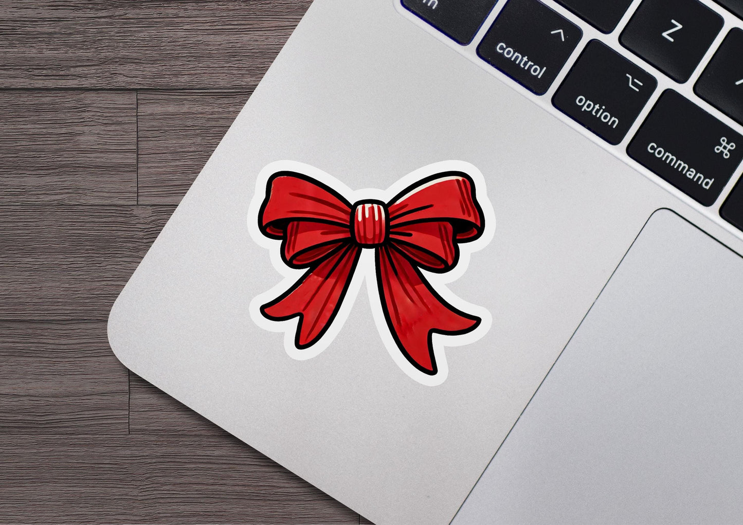 a laptop with a sticker of a red bow on it