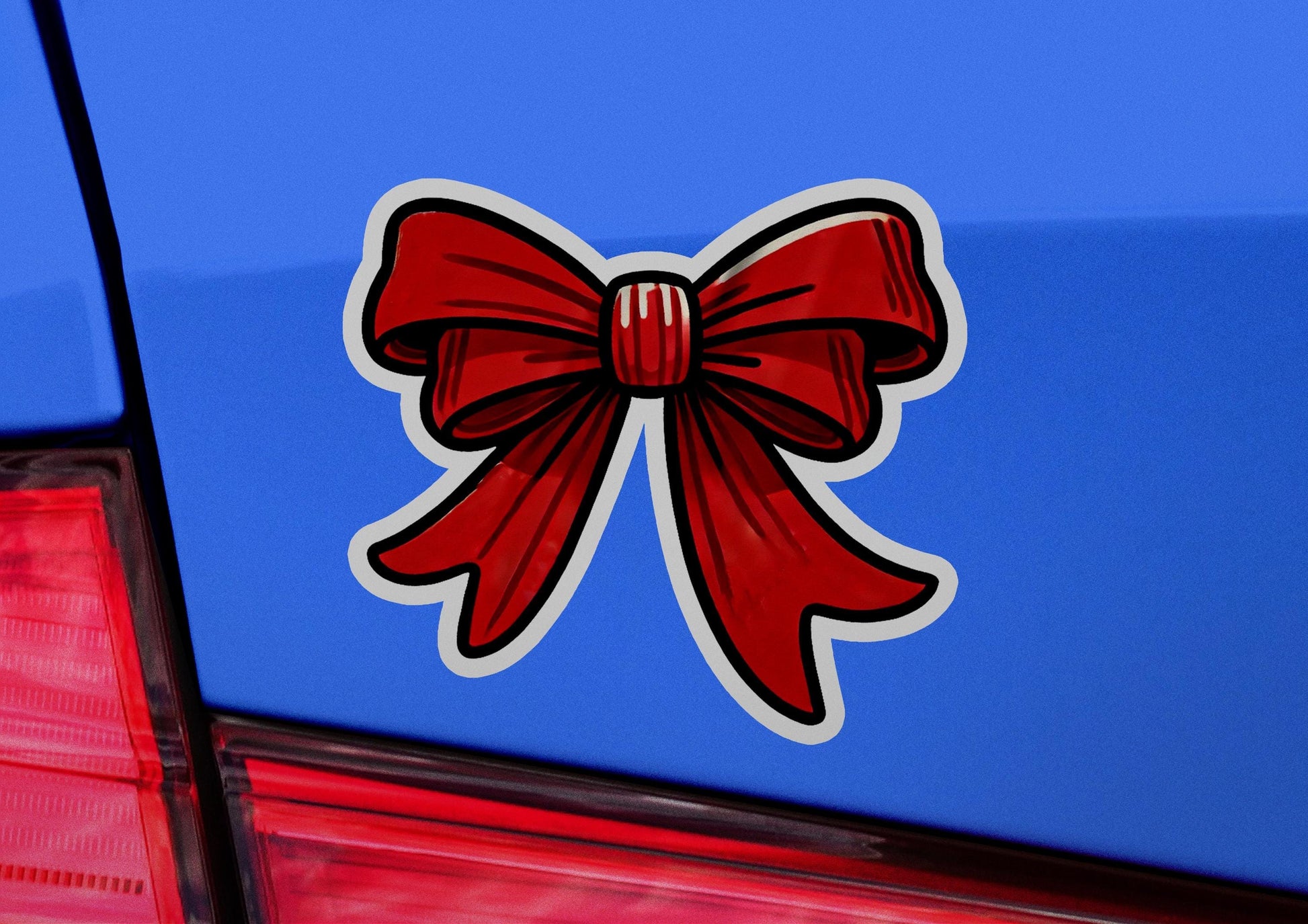 a red bow sticker on the back of a blue car