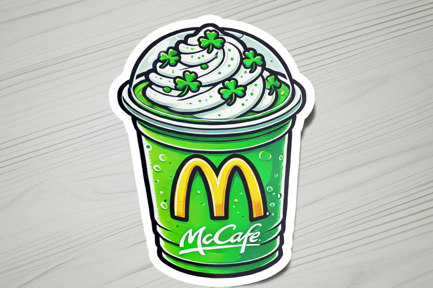 a sticker of a cup of coffee with whipped cream and shamrock leaves