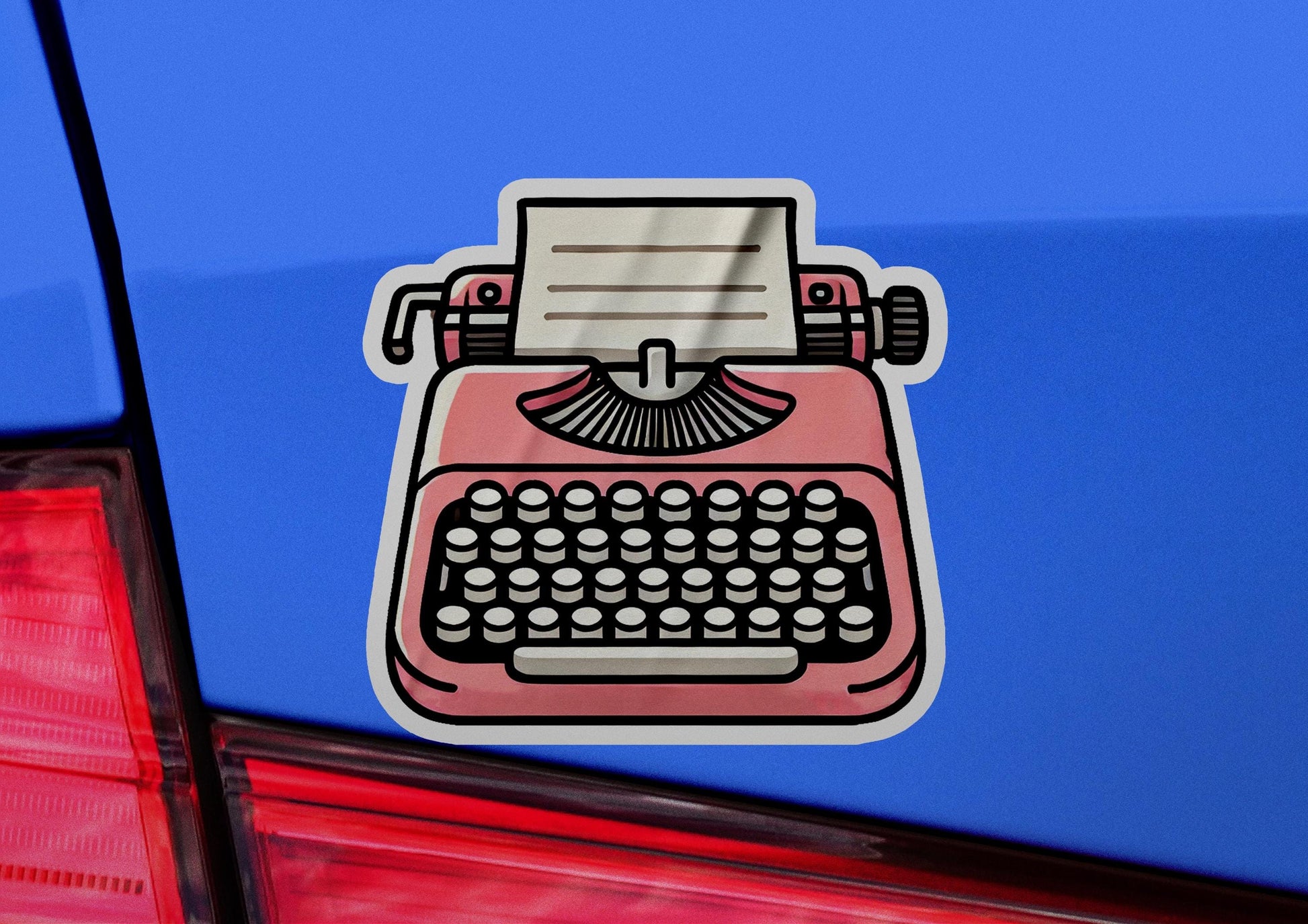 a sticker of a pink typewriter on the back of a car
