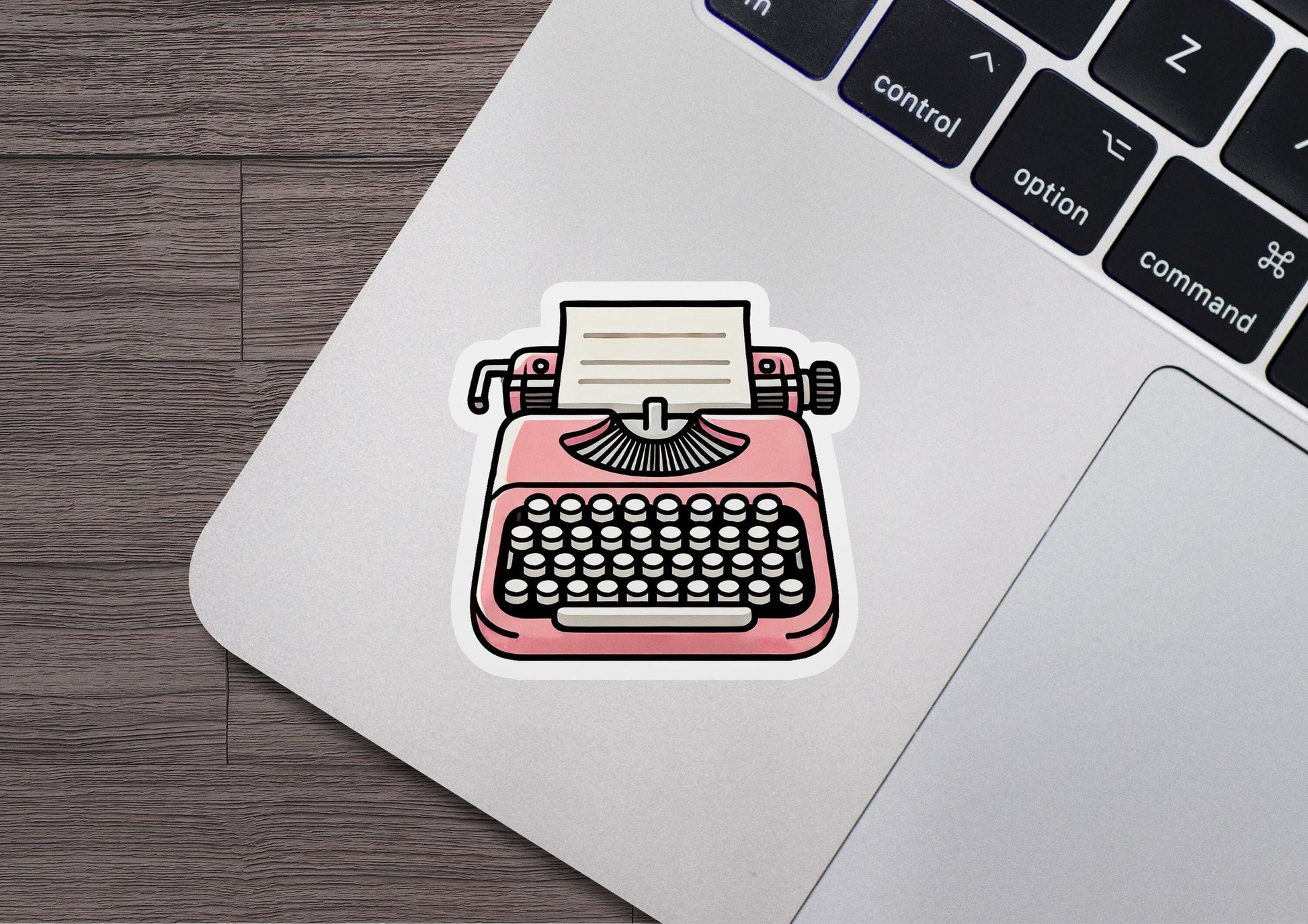 a laptop with a sticker of a pink typewriter