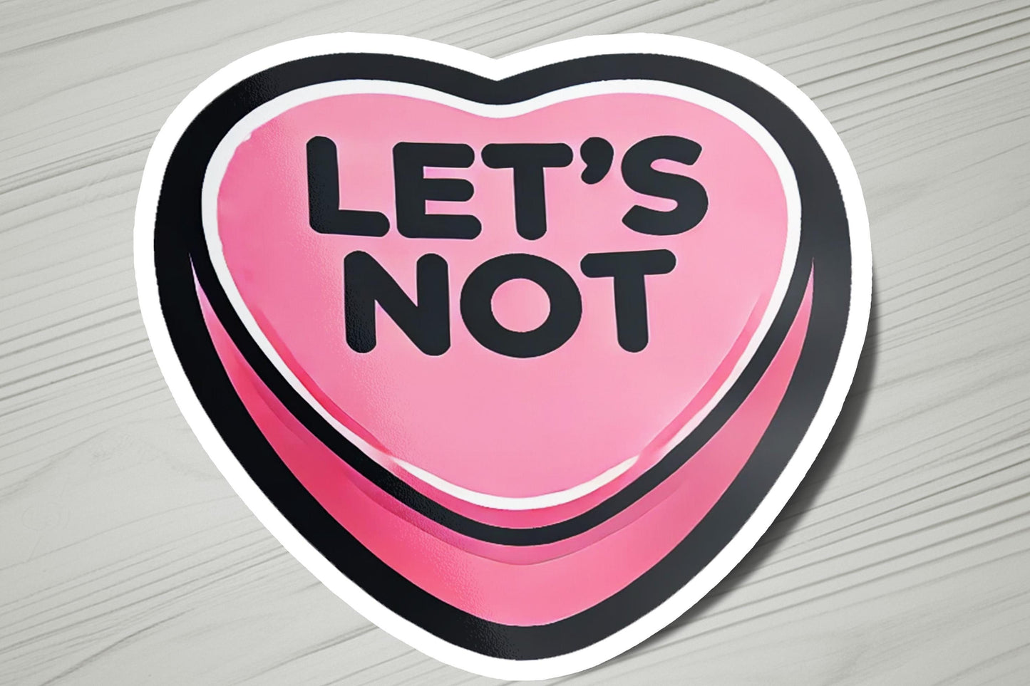 a pink heart shaped sticker that says let's not