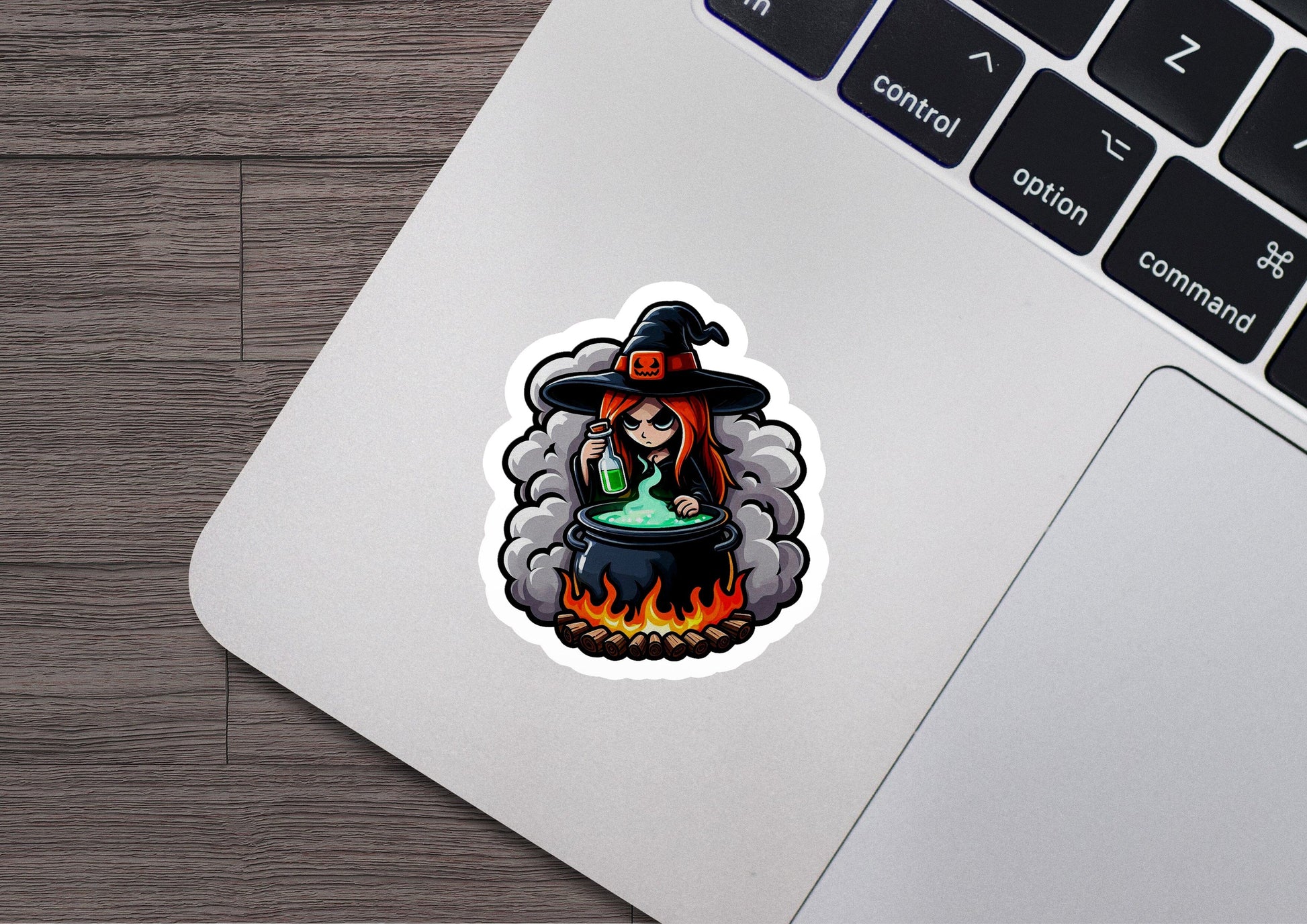 a laptop with a sticker of a witch on it