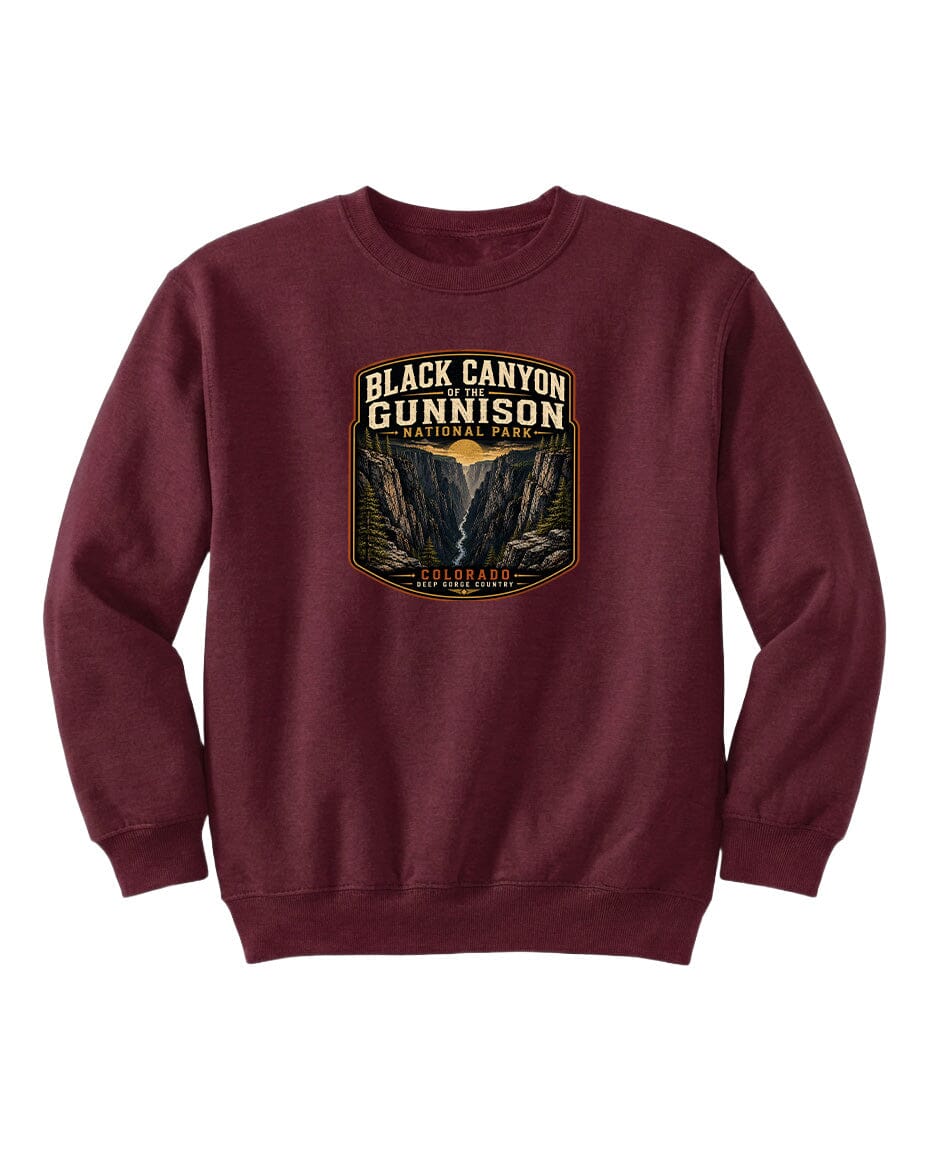 A burgundy sweatshirt with a graphic design featuring the text "Black Canyon Gunnison National Park" and an illustration of a canyon landscape.
