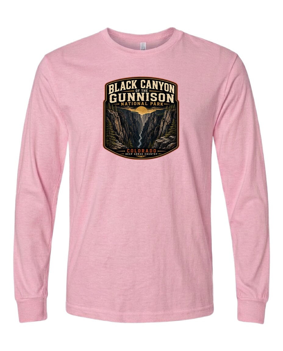 A pink long-sleeved t-shirt with a graphic design depicting the Black Canyon of the Gunnison National Park.
