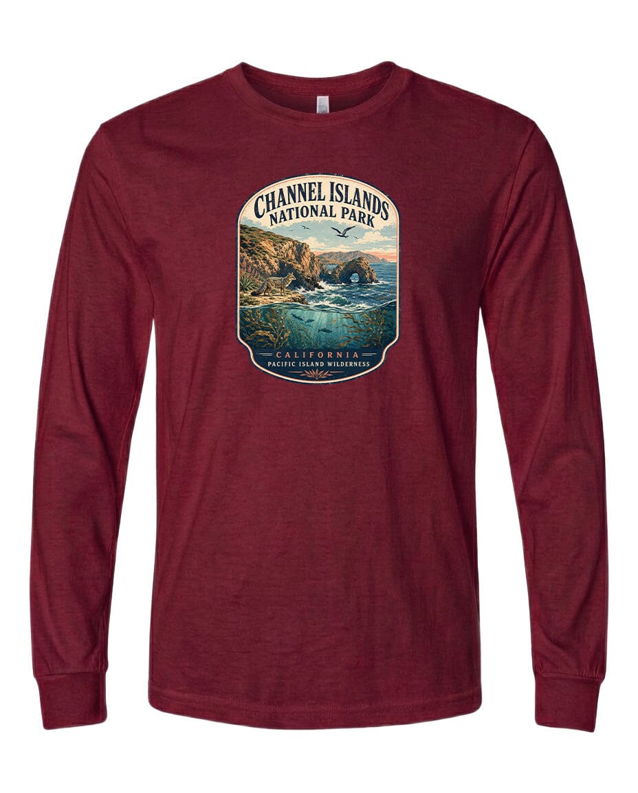 A red long-sleeved t-shirt with a graphic design depicting a scenic coastal landscape, including cliffs, water, and a sunset.
