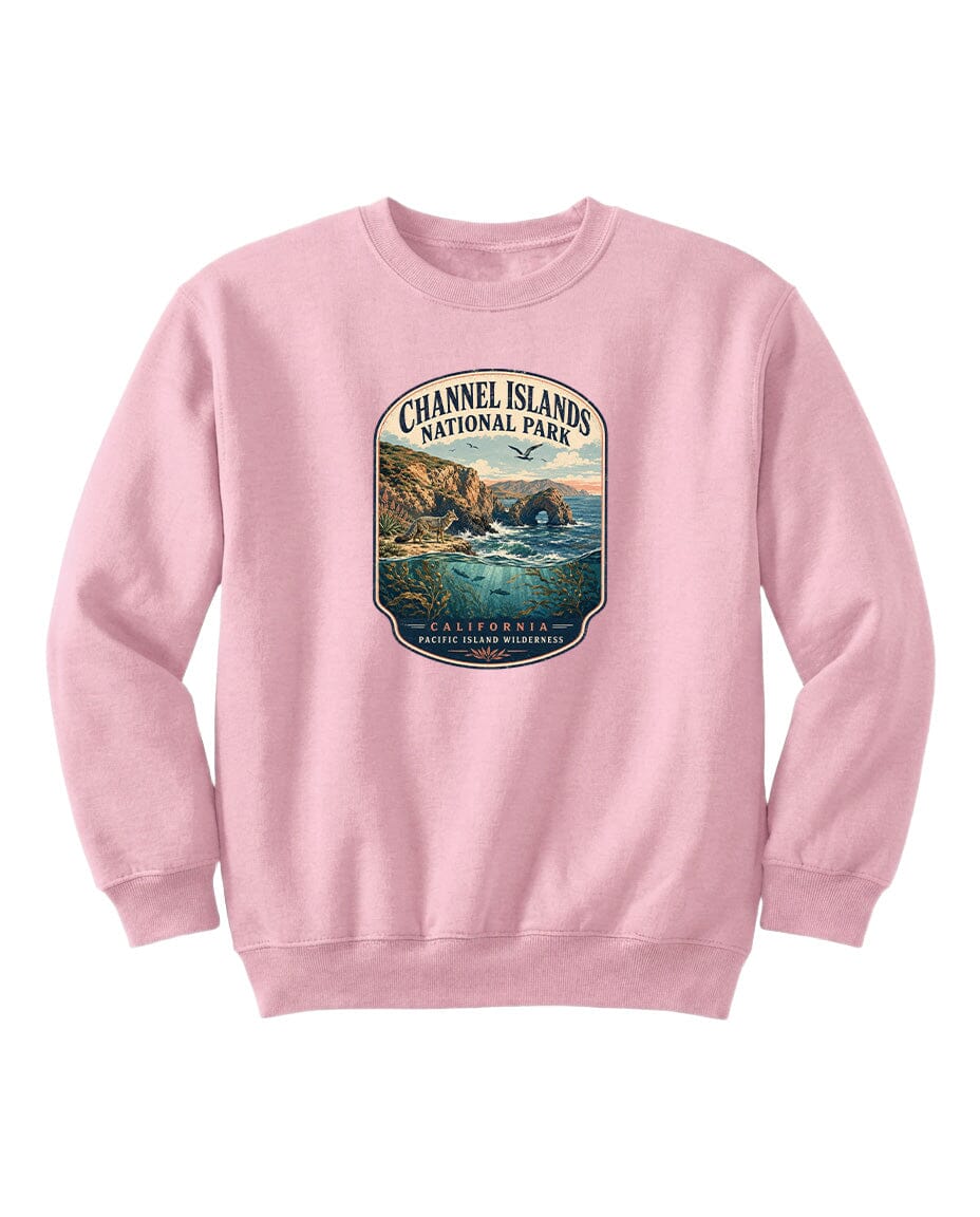 A pink sweatshirt with a graphic design depicting a scenic coastal landscape with cliffs, water, and a sunset.