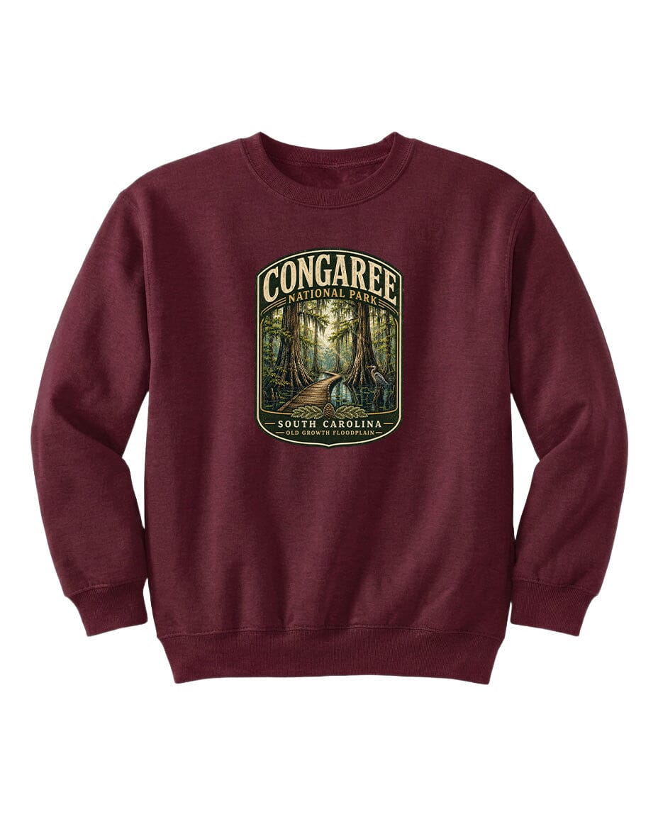 A burgundy sweatshirt with a graphic design depicting a forest scene, featuring the text "CONGAREE NATIONAL PARK SOUTH CAROLINA" prominently displayed.