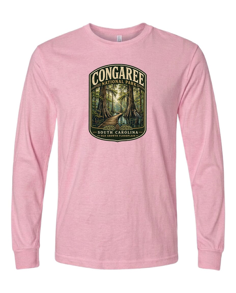 A pink long-sleeved t-shirt with a graphic design depicting a forest scene, featuring a path leading through the trees.