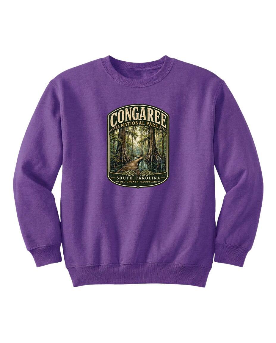 A purple sweatshirt with a graphic design depicting a forest path leading through Congaree National Park in South Carolina.