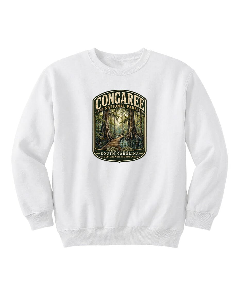 A white sweatshirt with a graphic design depicting a forest scene, featuring the text "CONGAREE NATIONAL PARK SOUTH CAROLINA" prominently displayed.