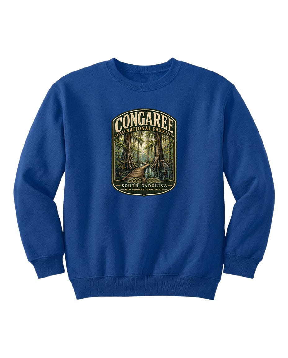A blue sweatshirt with a graphic design depicting a forest scene, featuring the text "CONGAREE NATIONAL PARK SOUTH CAROLINA" prominently displayed.