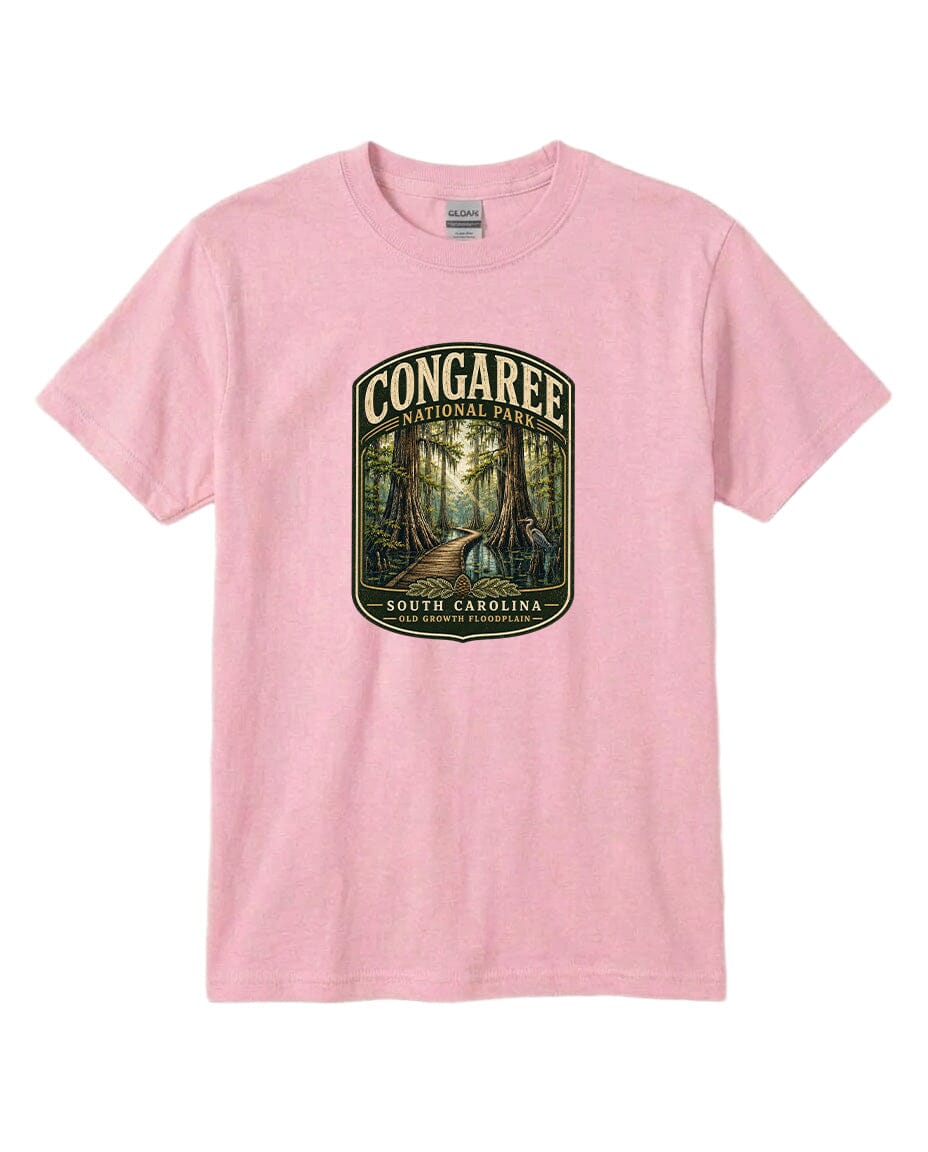 A pink t-shirt with a graphic design depicting a forest scene with a path leading through it, surrounded by trees.