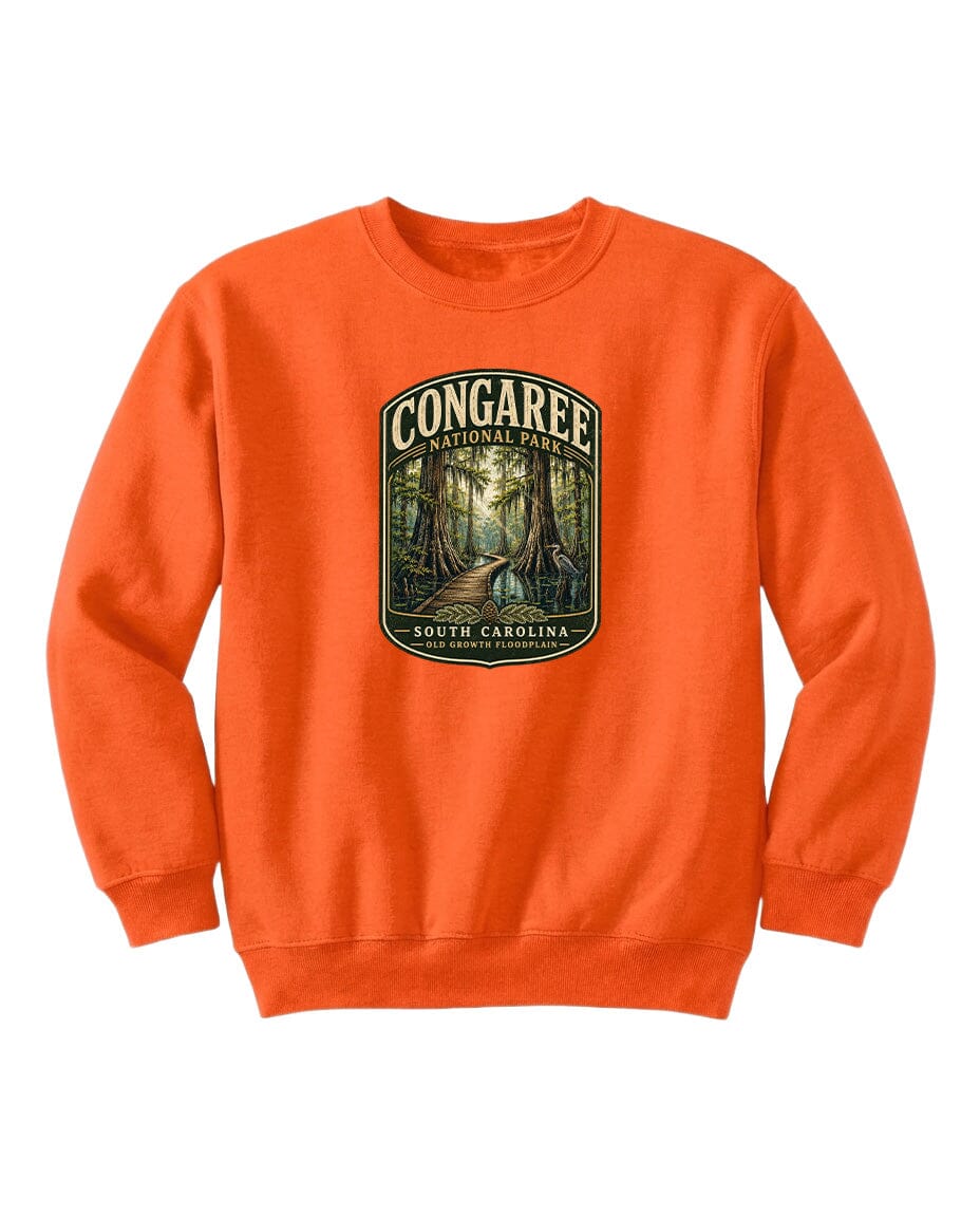An orange sweatshirt with a graphic design depicting a forest scene, featuring the text "CONGAREE NATIONAL PARK SOUTH CAROLINA" prominently displayed.