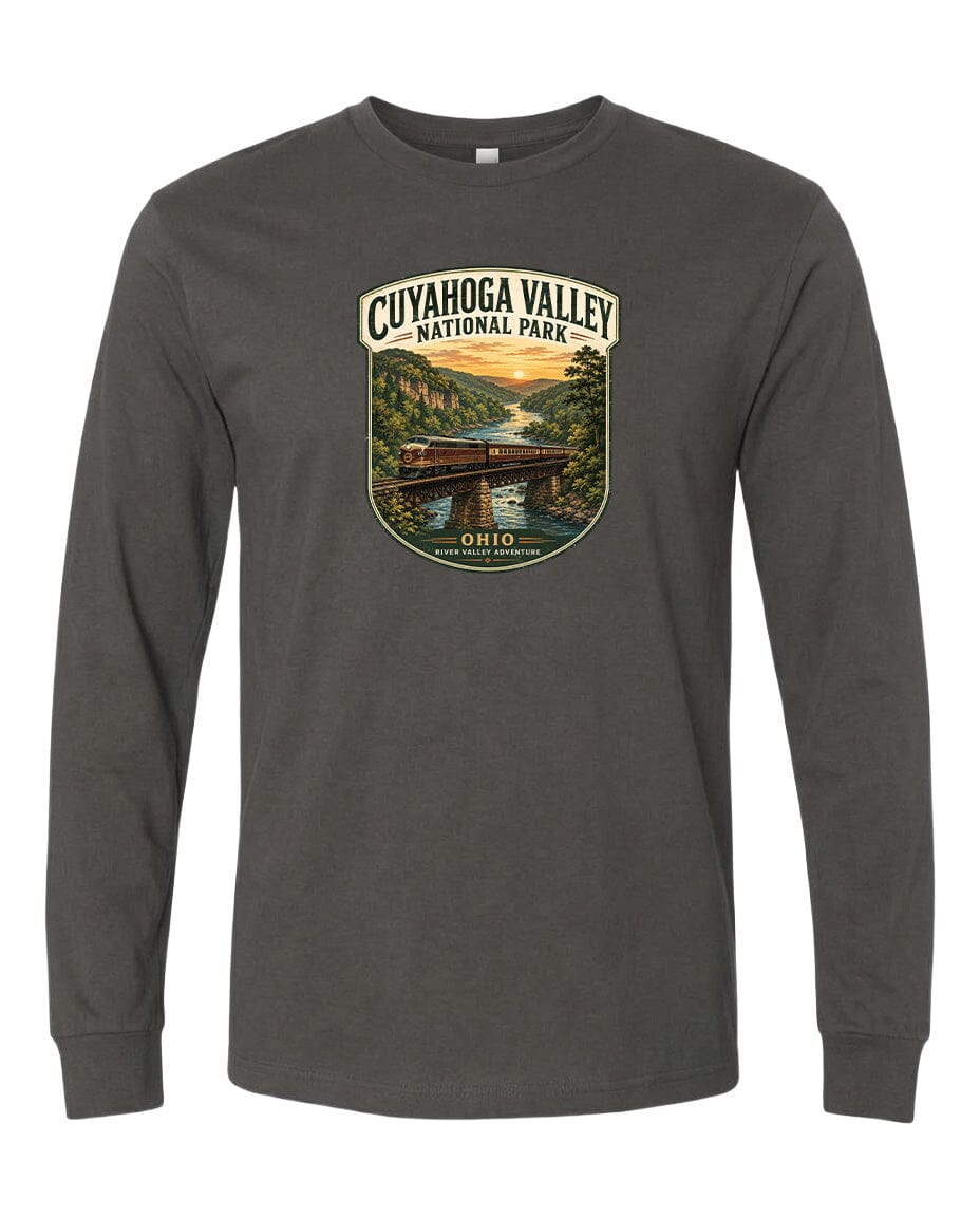 A gray long-sleeve t-shirt with a graphic design depicting a scenic view of the Cuyahog Valley National Park, featuring a bridge, trees, and a river.