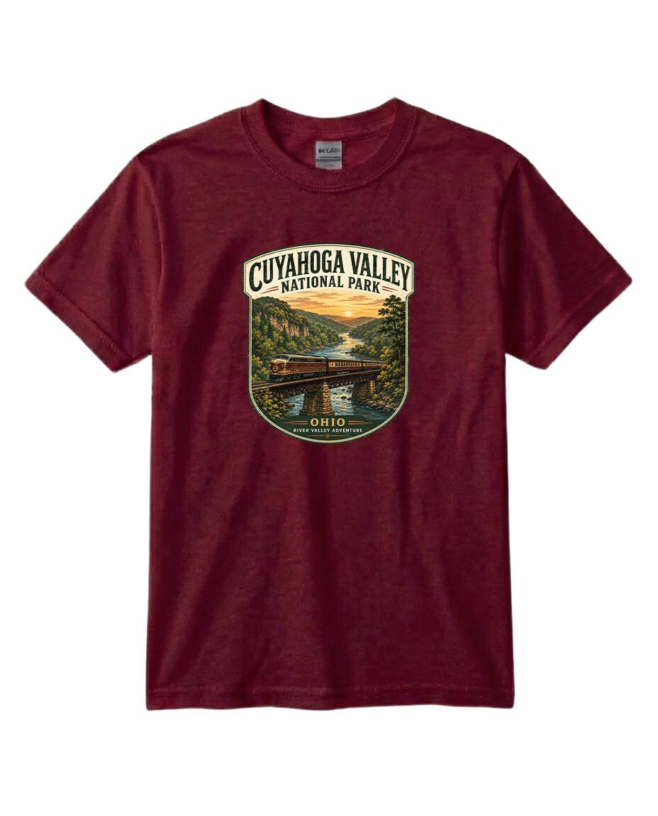 A burgundy-colored t-shirt with a graphic design depicting a scenic view of the Cuyahoga Valley National Park, featuring a bridge, trees, and a river.